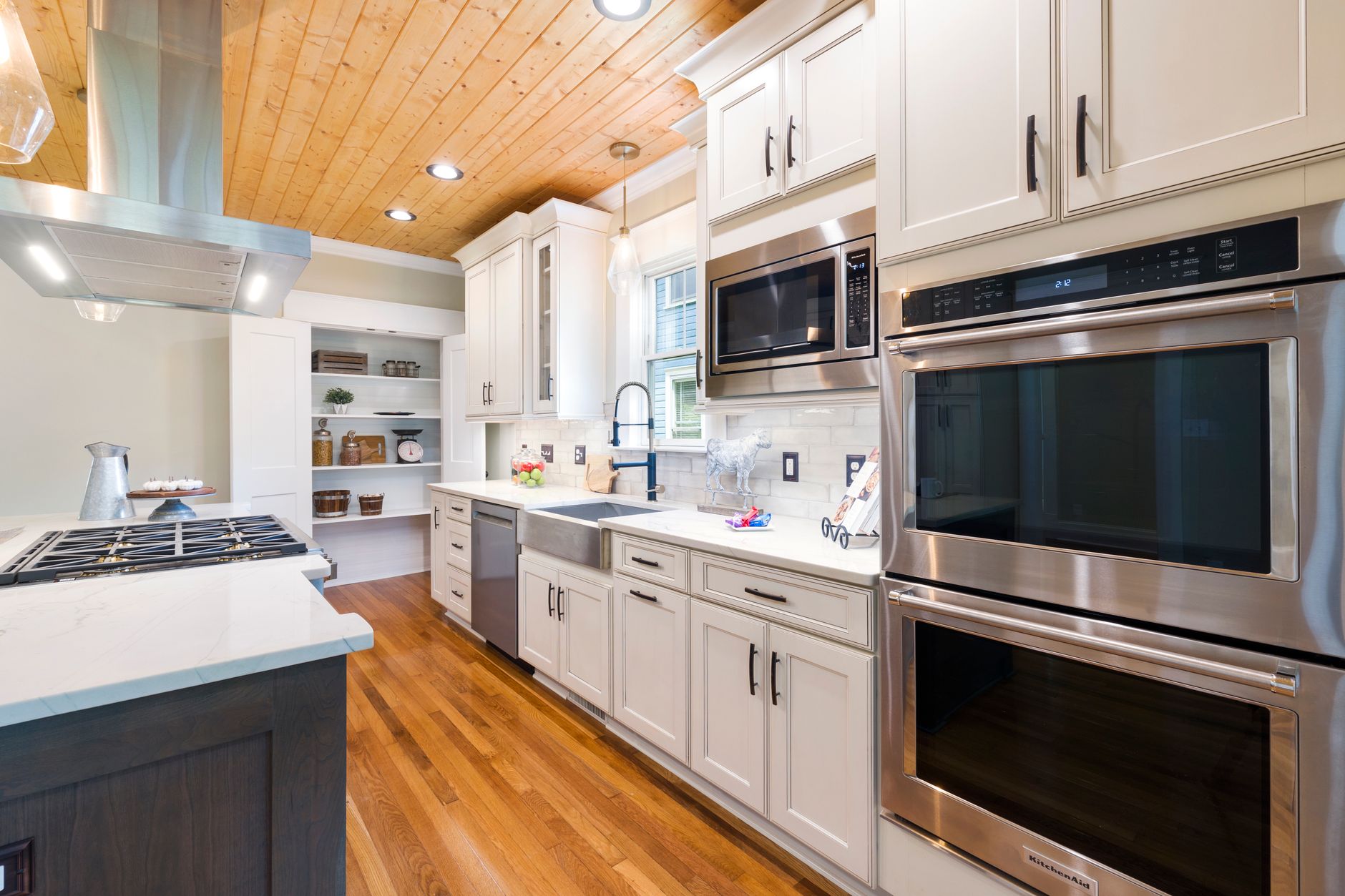 Bright remodeled kitchen with white cabinetry and wood floors